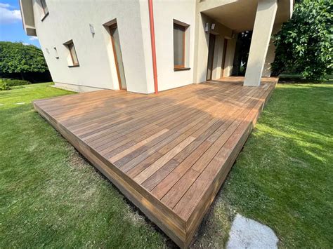 Ilustračná fotografia suchého dreva naskladaného na drevenej terase pod prístreškom.