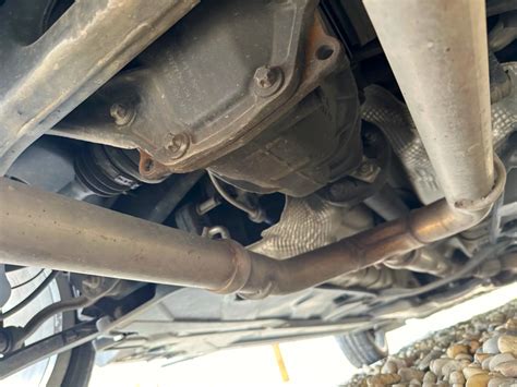 Detailný pohľad na termostat v motore auta, vrátane jeho hlavných komponentov.