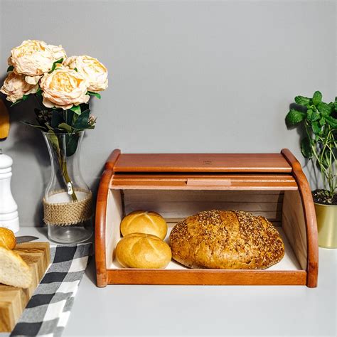 Fotografia moderného dreveného chlebníka s bochníkom chleba