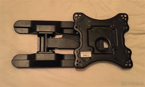 Detailný pohľad na robustnú oceľovú konzolu pripevnenú na stenu bytového domu, pripravenú na montáž vonkajšej jednotky klimatizácie.