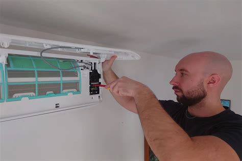 Detailný pohľad na odpojenie hadíc od starého výmenníka klimatizácie.