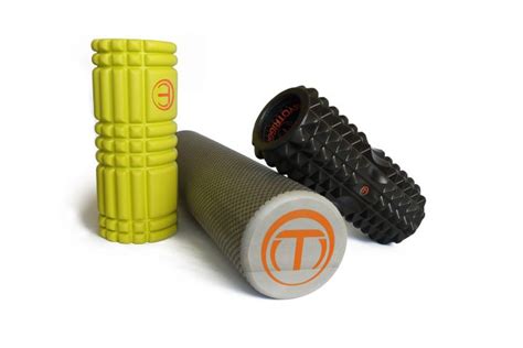 Športovec používajúci foam roller na masáž lýtok po tréningu.