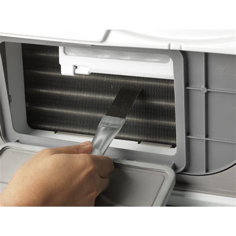 Ilustrácia čistenia zadného kondenzátora chladničky mäkkou kefou