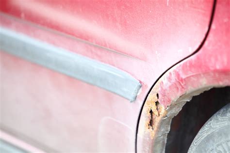 Detailné zobrazenie korózie na leme blatníka automobilu