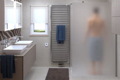Tematické foto: moderná kúpeľňa s elektrickým rebríkovým radiátorom, na ktorom sú sušiace sa uteráky