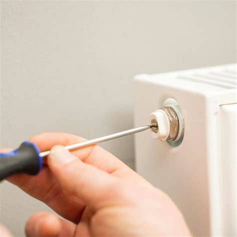 Ilustrácia potrebných nástrojov na odvzdušnenie radiátora: odvzdušňovací kľúč, miska a handra.